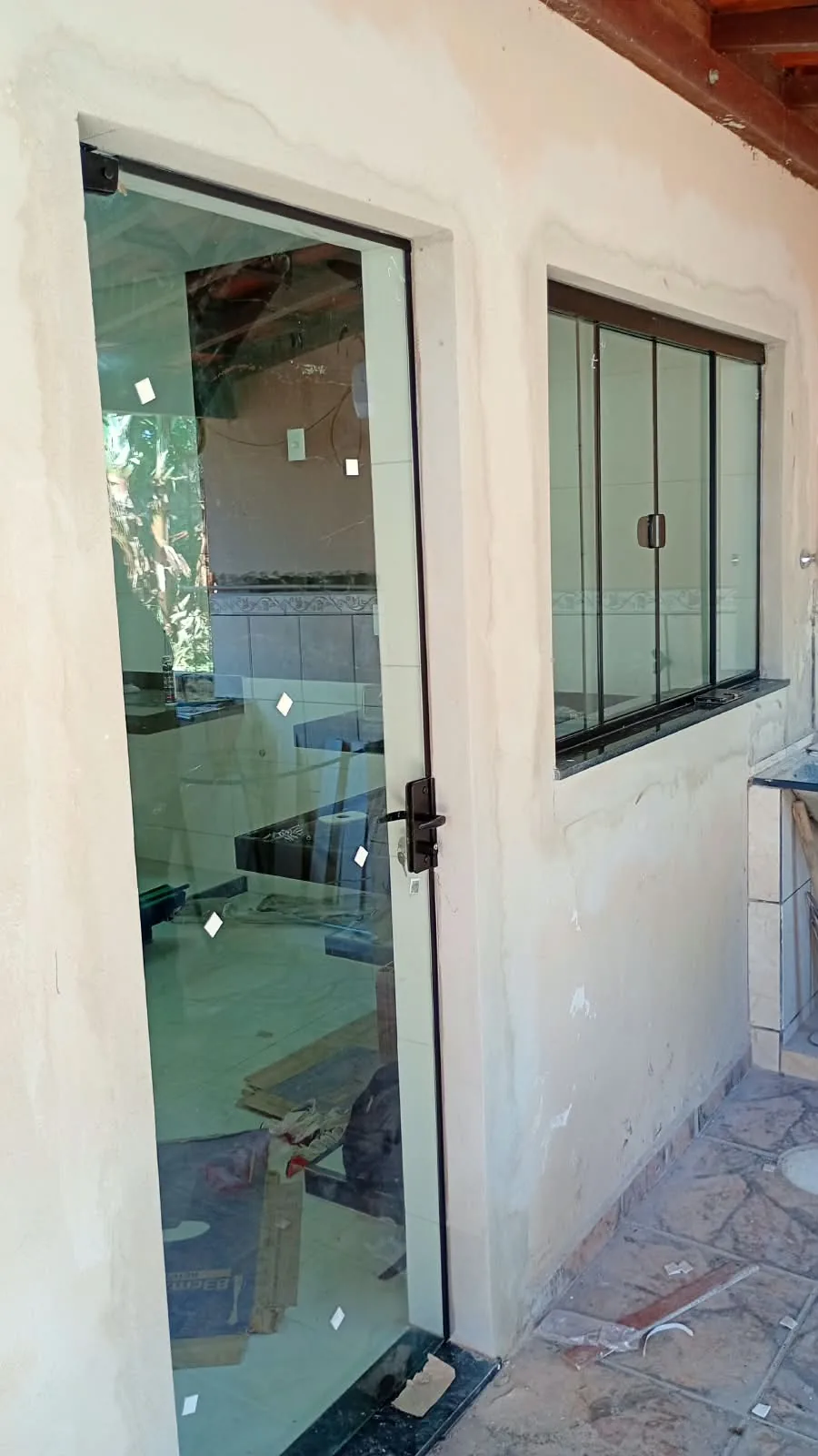 Portas de Vidro em Lavras — Porta de vidro e janela de correr em vidro com perfis pretos em área externa — portas e janelas de vidro em Lavras